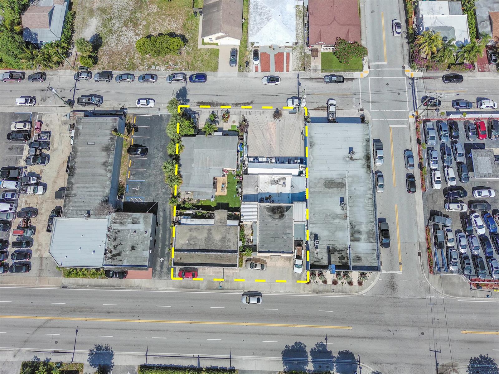 Aerial view of a commercial property lot outlined in yellow between two larger buildings — 922 & 928 S Dixie Highway, FL 33462, FL