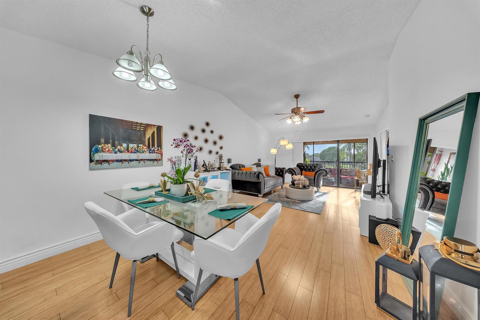 A bright open-concept living and dining area features light wood flooring and a vaulted ceiling — 1023 Banks Road # 201, Margate FL 33063, MARGATE, FL