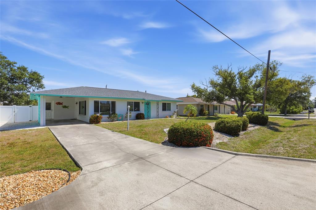 A single-story house with a white exterior, turquoise trim, and a concrete driveway — 2101 JO AN DRIVE, SARASOTA, FL