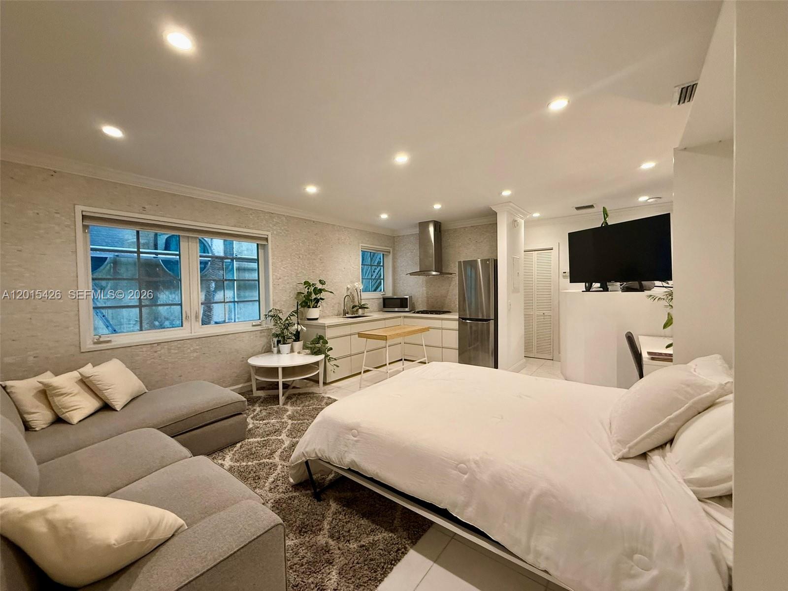 This studio apartment features a bed, a sofa, and a kitchen with stainless steel appliances — 260 Euclid Ave # 24, Miami Beach FL 33139, MIAMI BEACH, FL
