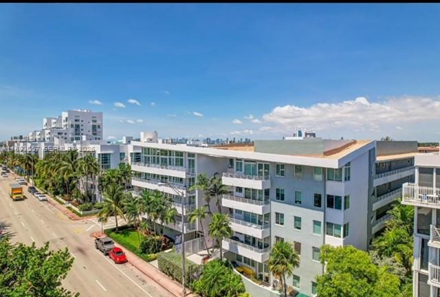 An exterior view of a multi-story apartment building with balconies along a city street — 7800 Collins Ave # 203, Miami Beach FL 33141, MIAMI BEACH, FL