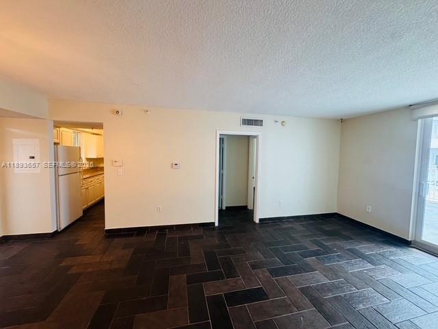 An interior room features dark herringbone-patterned tile flooring, white walls, and a doorway leading inside — 7800 Collins Ave # 203, Miami Beach FL 33141, MIAMI BEACH, FL