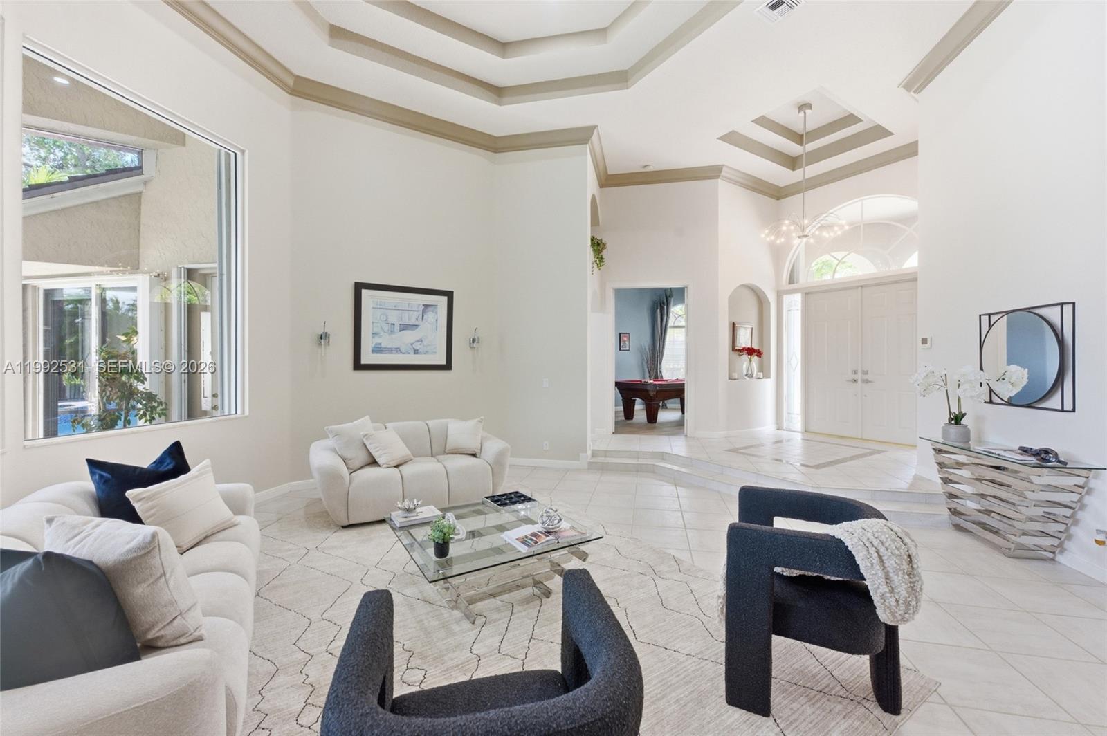 A bright living room features a tray ceiling, tile flooring, and a sunken entryway — 2488 Provence Cir, Weston FL 33327, WESTON, FL
