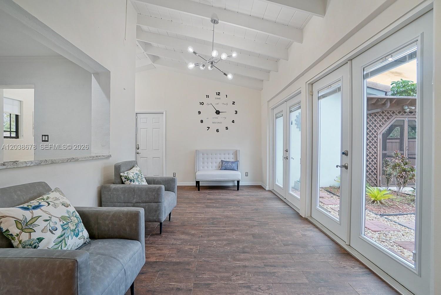 A bright room features wood-look tile floors, a vaulted ceiling, and glass doors to a patio — 850 NE 182nd Ter, North Miami Beach FL 33162, NORTH MIAMI BEACH, FL