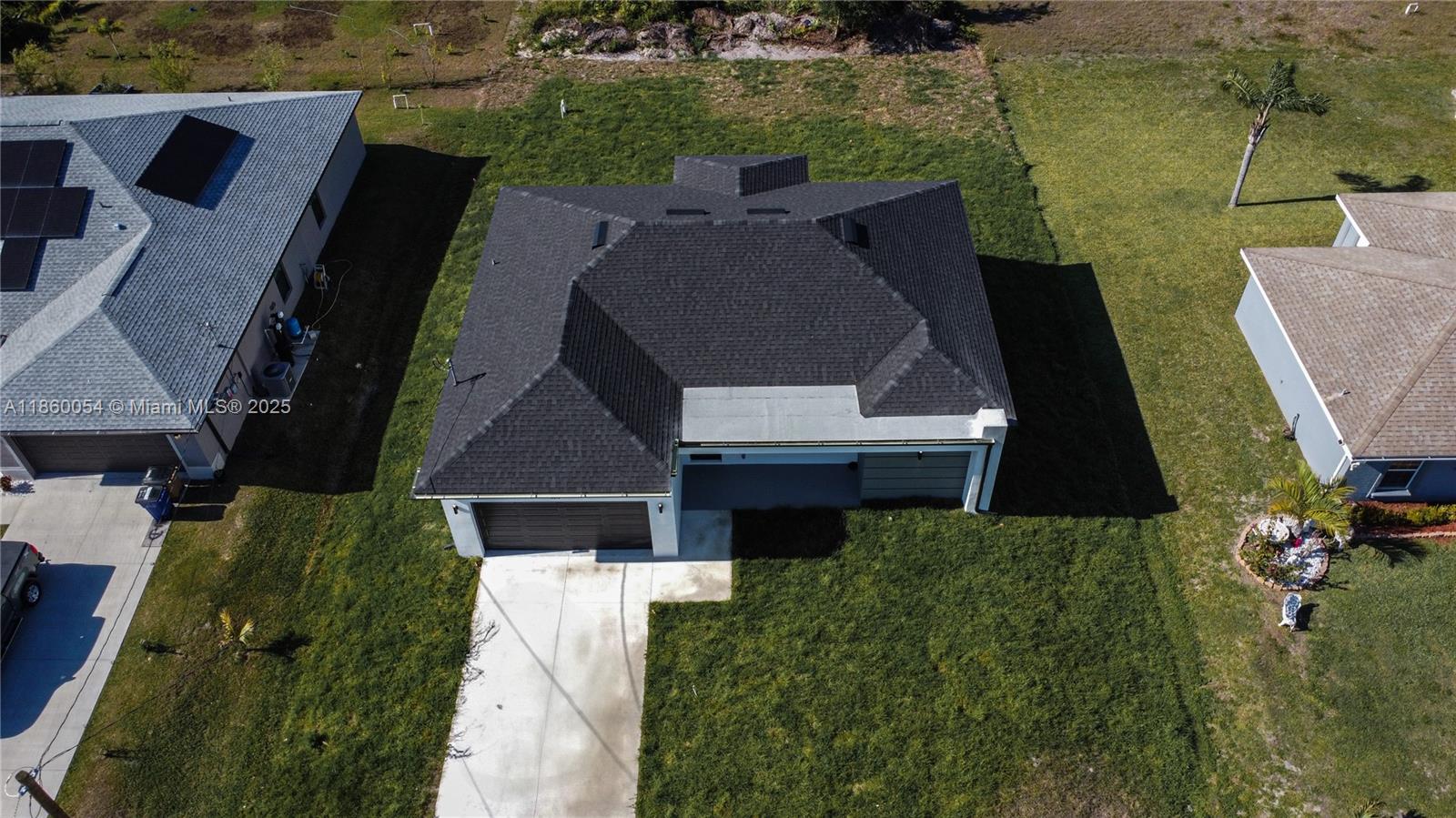 An aerial view shows a single-story house with a dark shingled roof and driveway — 3610 SW 22ND ST, Lehigh Acres FL 33976, LEHIGH ACRES, FL