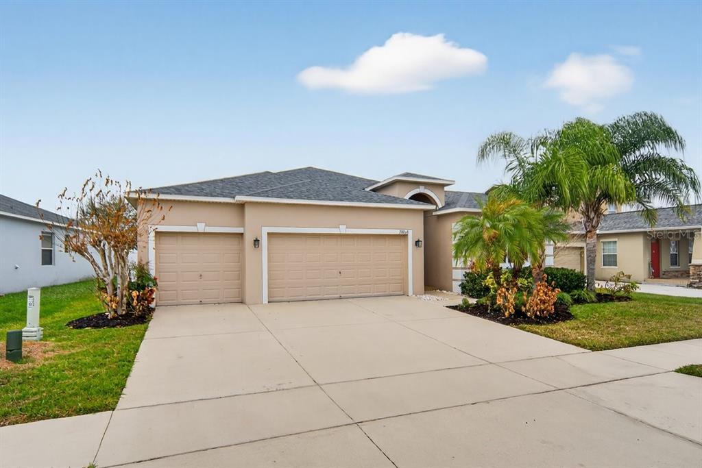 A tan, single-story suburban house with a three-car garage and a concrete driveway — 2854 YOUNGFORD STREET, ORLANDO, FL