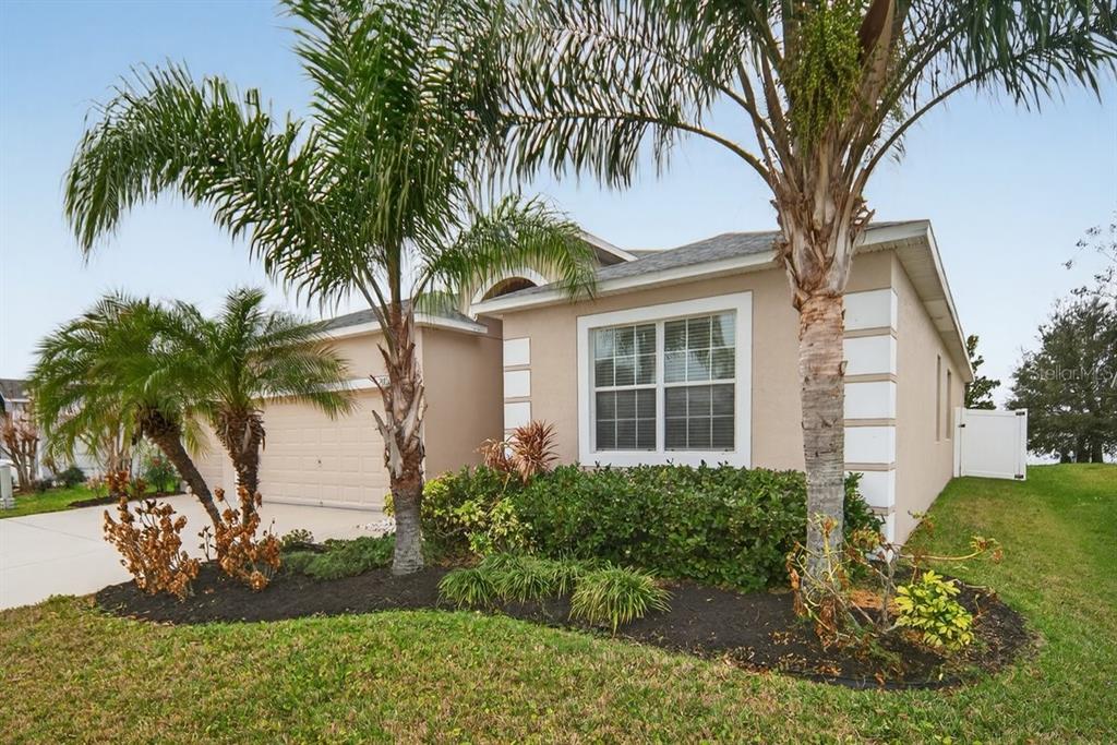 A single-story house with a beige stucco exterior, a two-car garage, and several palm trees — 2854 YOUNGFORD STREET, ORLANDO, FL