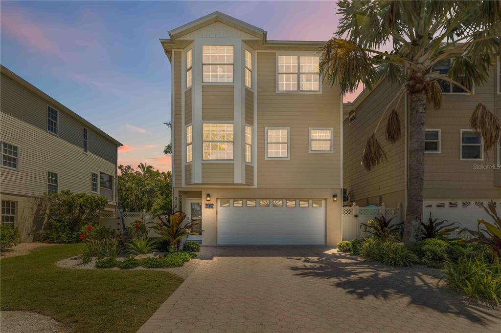 A three-story tan house with a two-car garage and a paved driveway — 215 81ST STREET, HOLMES BEACH, FL