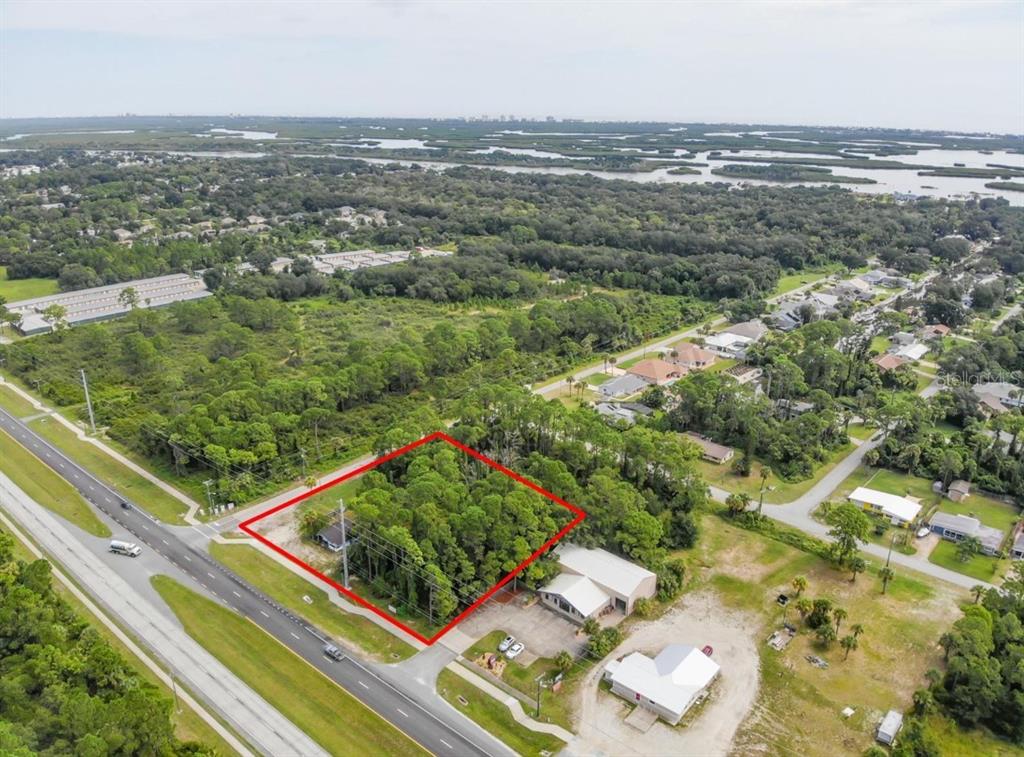 An aerial view shows a wooded, rectangular lot outlined in red next to a highway — 3609 S RIDGEWOOD AVENUE UNIT 0, EDGEWATER, FL