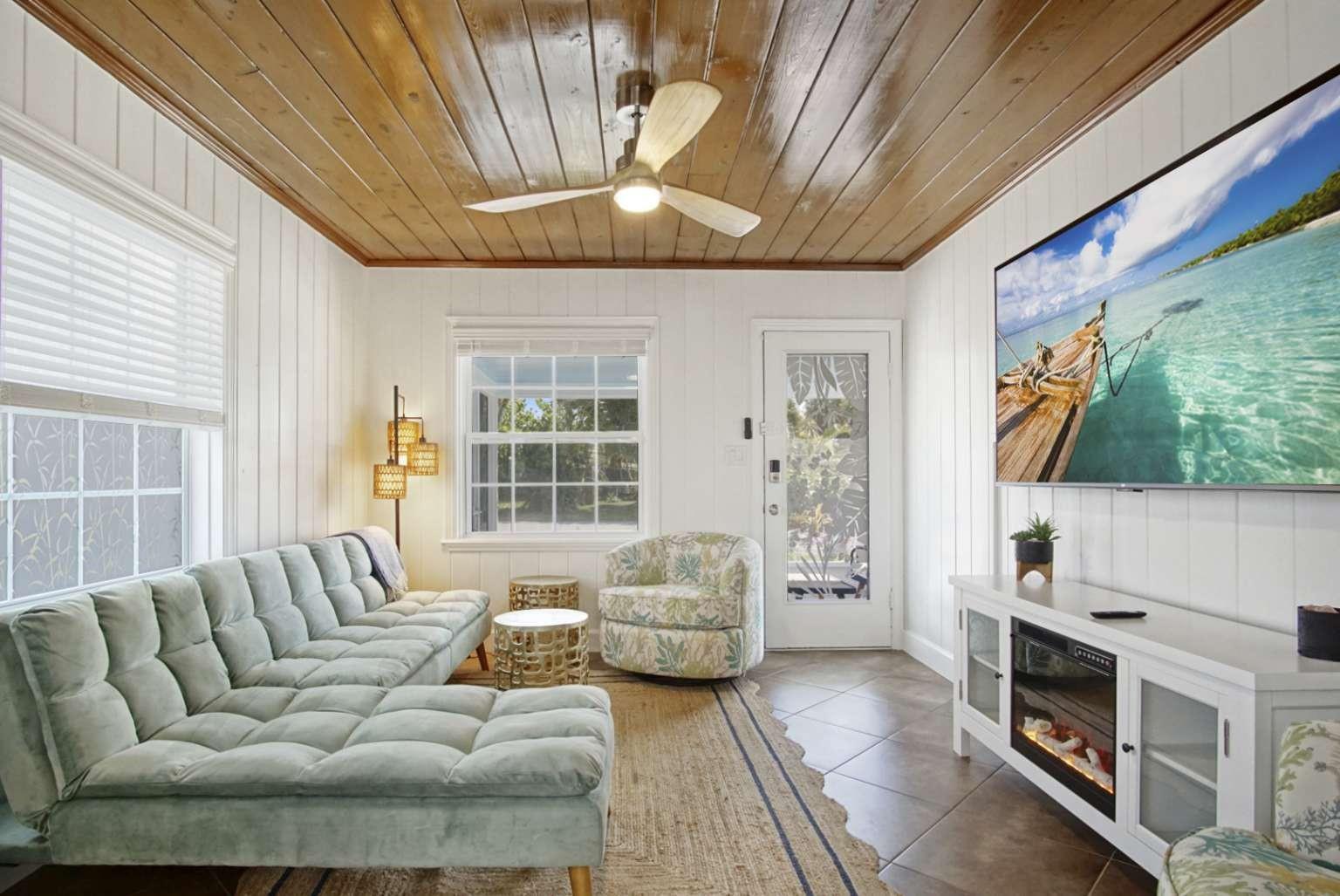 A living room features a wood-paneled ceiling, white vertical wall paneling, and a light-colored sofa — 307 Granada Street, Fort Pierce FL 34949, FORT PIERCE, FL