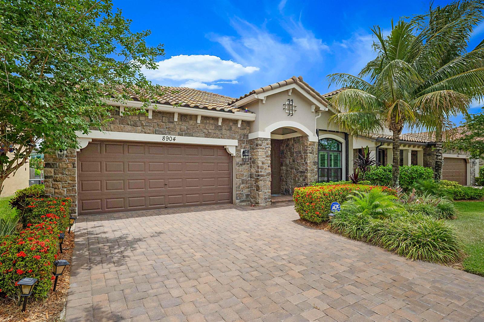 A single-story house with a stone facade, a tiled roof, and a paved driveway — 8904 Sea Chase Drive, Lake Worth FL 33467, LAKE WORTH, FL
