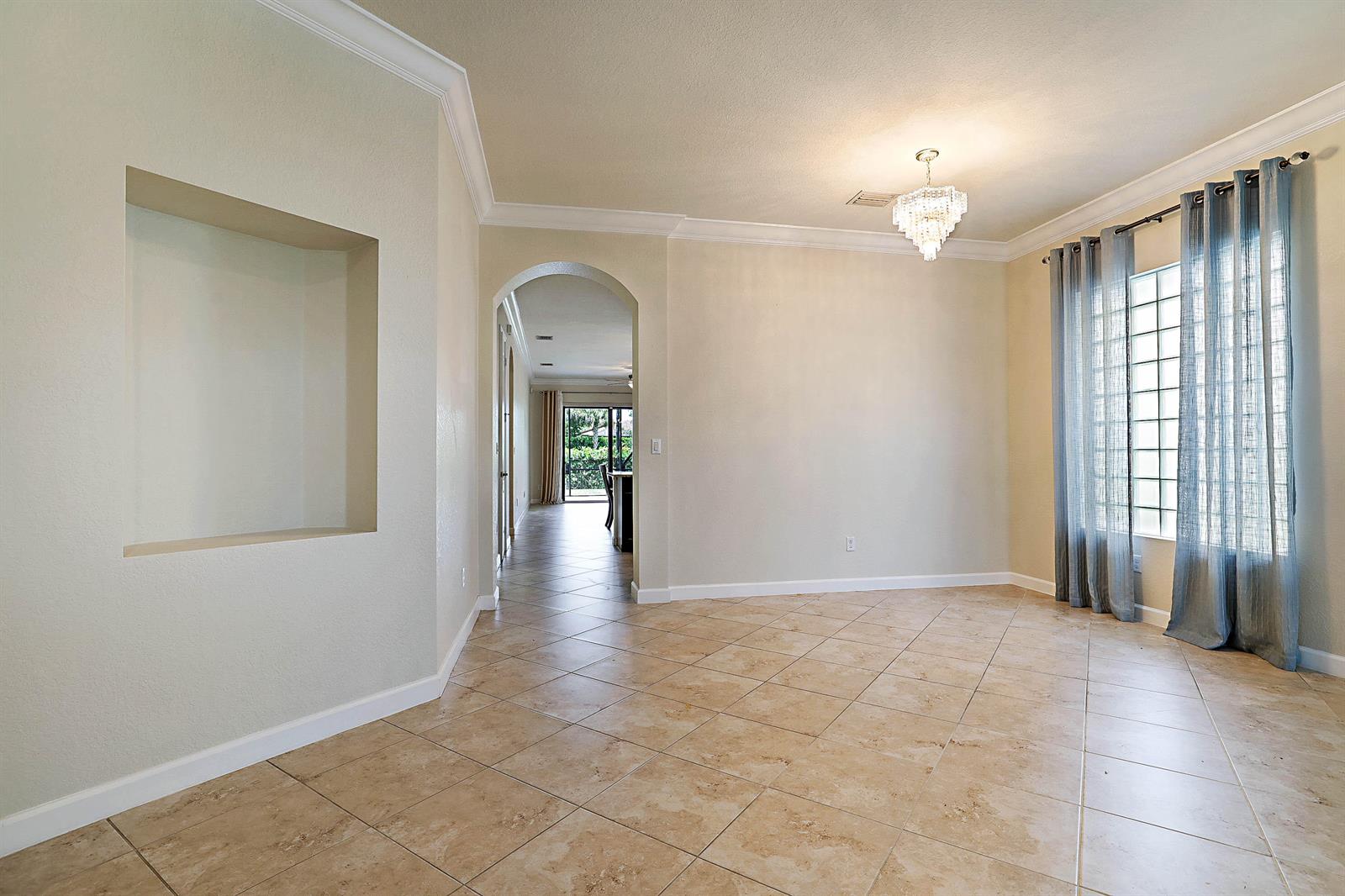 A dining room with tile floors, a crystal chandelier, and a recessed wall niche — 8904 Sea Chase Drive, Lake Worth FL 33467, LAKE WORTH, FL