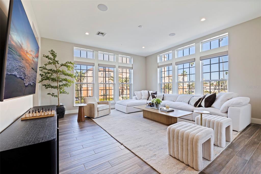 A bedroom features a bed, a patterned rug, a chair, and glass doors to a balcony — 91 DAVIS BOULEVARD UNIT 201, TAMPA, FL