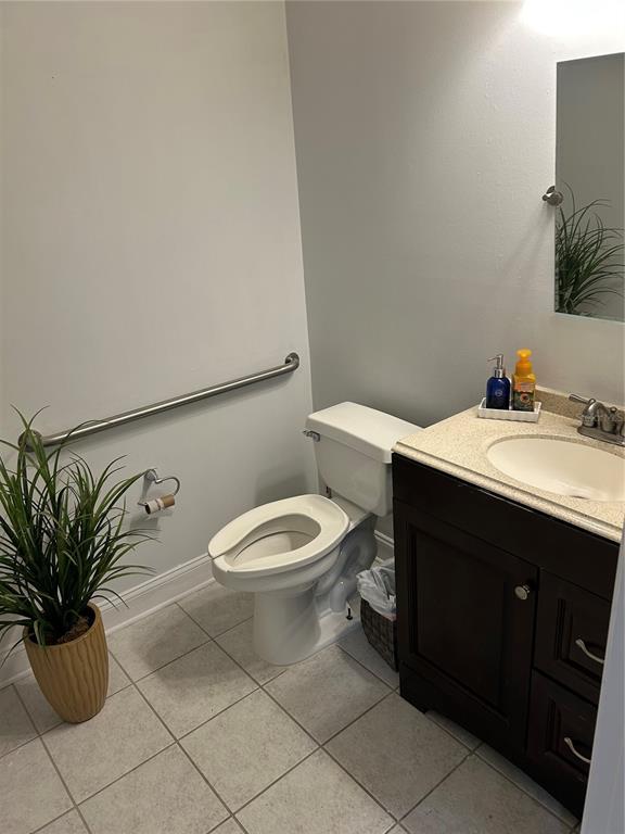 A bathroom features a toilet, a vanity with a sink, and a wall-mounted grab bar — 5216 SW 91ST TERRACE, GAINESVILLE, FL