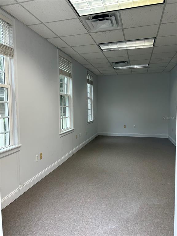 An empty office space features light gray walls, carpeted flooring, and a drop ceiling — 5216 SW 91ST TERRACE, GAINESVILLE, FL