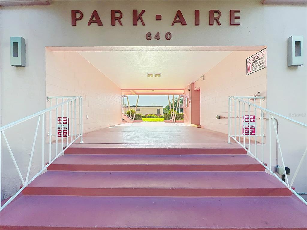 A set of pink concrete stairs leads to an open-air breezeway at an apartment building — 640 N PARK AVENUE UNIT 4, WINTER PARK, FL