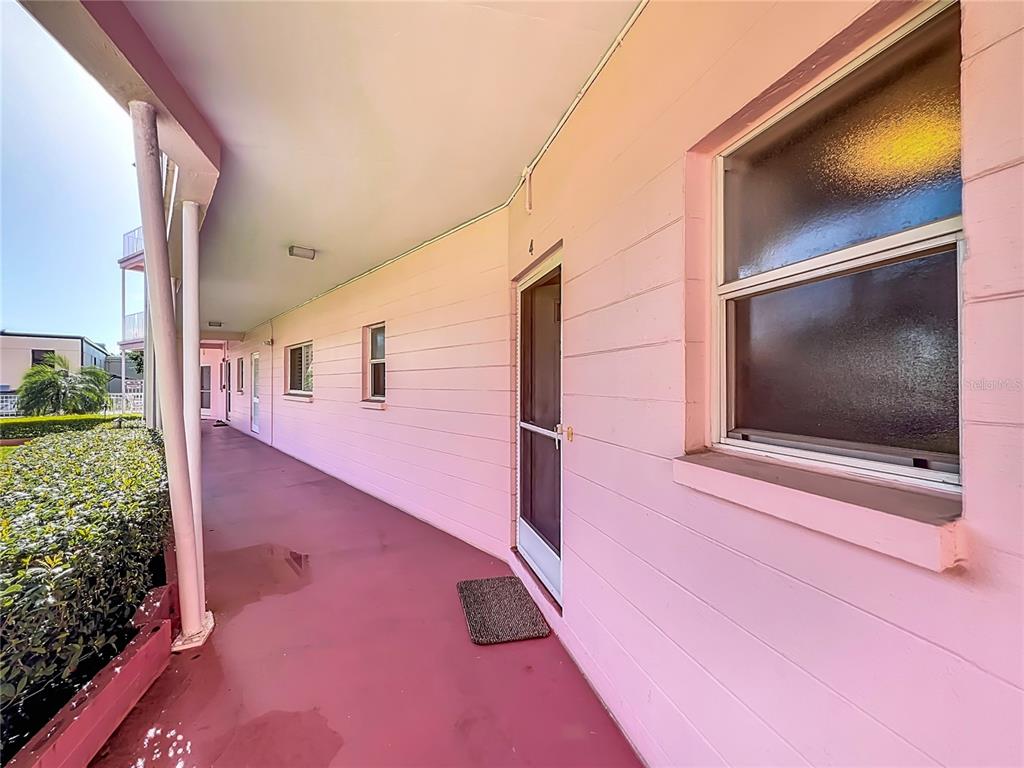 A pink exterior walkway features a row of doors and windows along a building — 640 N PARK AVENUE UNIT 4, WINTER PARK, FL