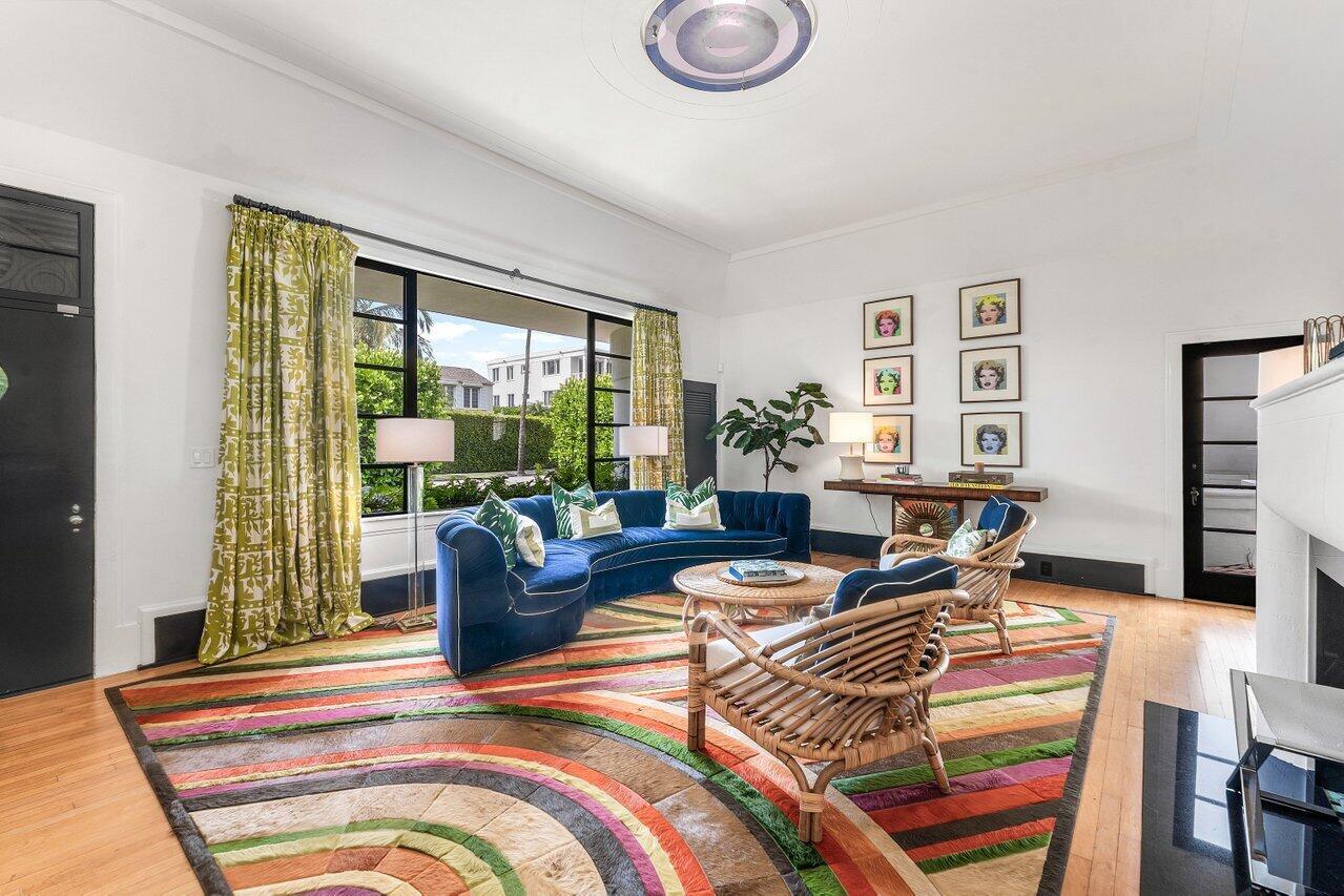 A living room features a blue curved sofa, rattan chairs, and a colorful striped rug — 162 Peruvian Avenue, Palm Beach FL 33480, PALM BEACH, FL