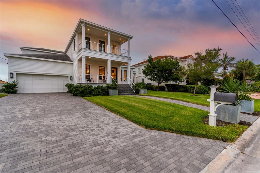 A covered patio with outdoor furniture overlooks a swimming pool and a calm body of water — 5811 MARINER STREET, TAMPA, FL