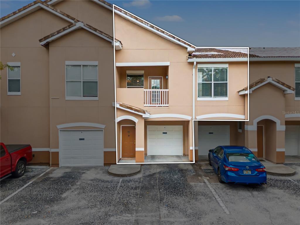 An exterior view of a two-story townhouse with a garage and a second-floor balcony — 18111 VILLA CREEK DRIVE UNIT 18111, TAMPA, FL