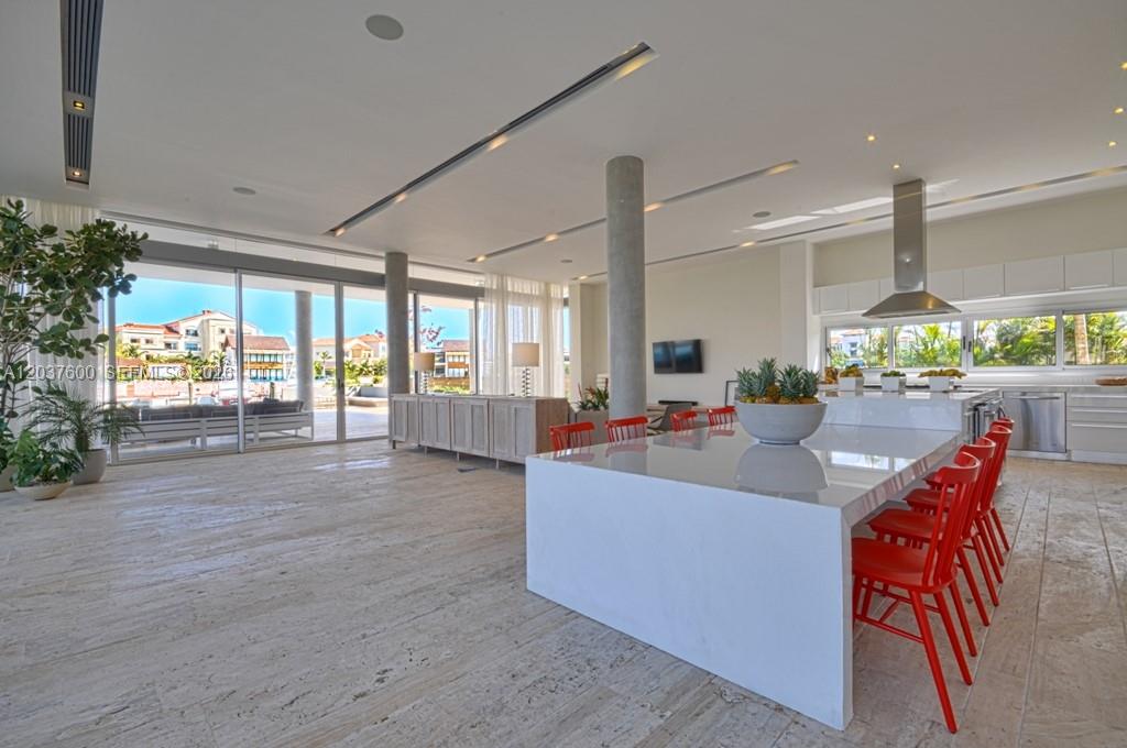A modern open-concept kitchen and living area with a large white island and red chairs — 0 Marina cc, FL, FL