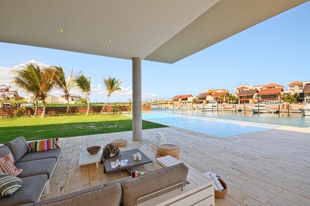 A covered patio features outdoor seating overlooking a swimming pool and a boat-filled canal — 0 Marina cc, FL, FL