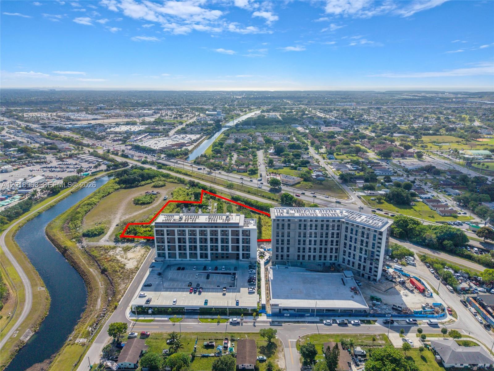 An aerial view shows two large apartment buildings with parking lots and a highlighted vacant lot — 21281 SW 117th Ave, Miami FL 33177, MIAMI, FL
