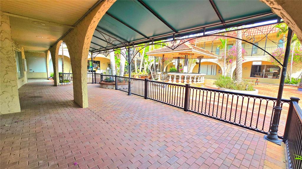 A covered brick walkway overlooks a courtyard with a gazebo and surrounding commercial buildings — 530 US-41-BYP UNIT 20-21A, VENICE, FL