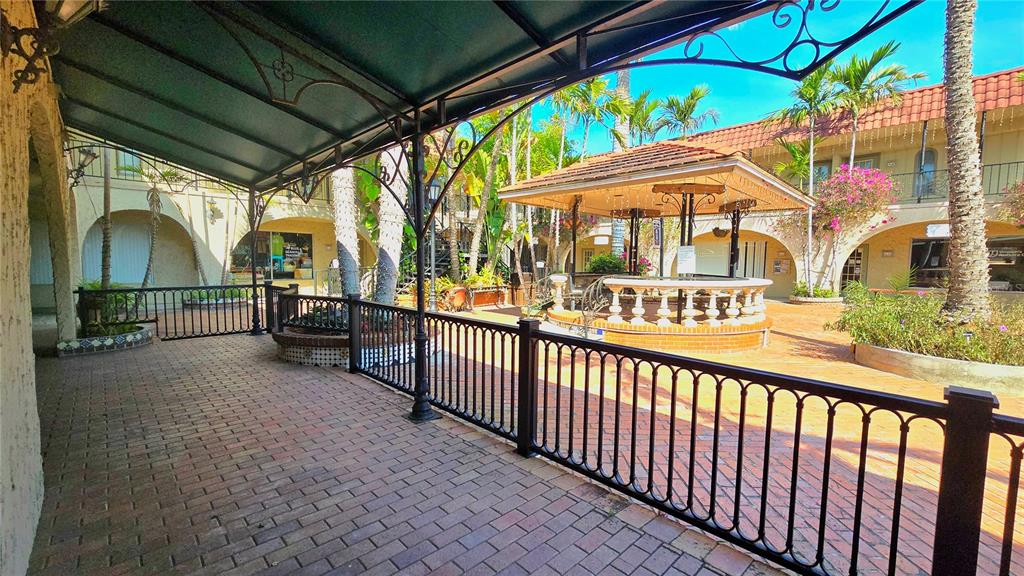 A brick-paved courtyard features a covered walkway, a central gazebo, and lush tropical landscaping — 530 US-41-BYP UNIT 20-21A, VENICE, FL