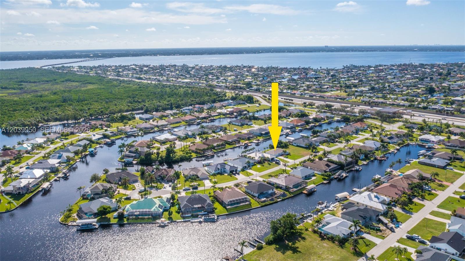 An aerial view shows a residential neighborhood with houses situated along a network of canals — 2219 SE 19 PL, Cape Coral FL 33990, CAPE CORAL, FL