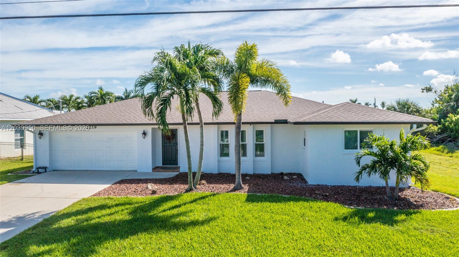 A white single-story house with a garage, palm trees, and a green lawn — 2219 SE 19 PL, Cape Coral FL 33990, CAPE CORAL, FL