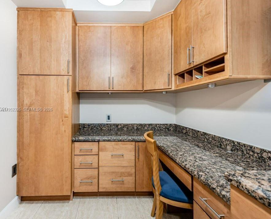 A home office features light wood cabinetry, granite countertops, and a built-in desk area — 4001 Hillcrest Dr # 914, Hollywood FL 33021, HOLLYWOOD, FL