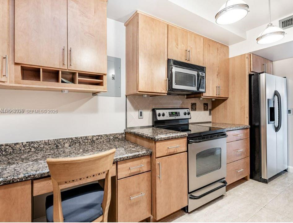 A kitchen features light wood cabinets, granite countertops, stainless steel appliances, and a built-in desk — 4001 Hillcrest Dr # 914, Hollywood FL 33021, HOLLYWOOD, FL