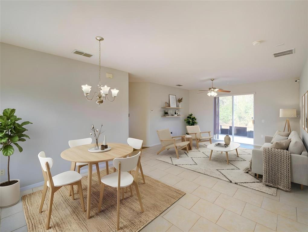 An open-concept living and dining area features light tile floors, neutral walls, and sliding doors — 735 PALAISEAU CT, KISSIMMEE, FL