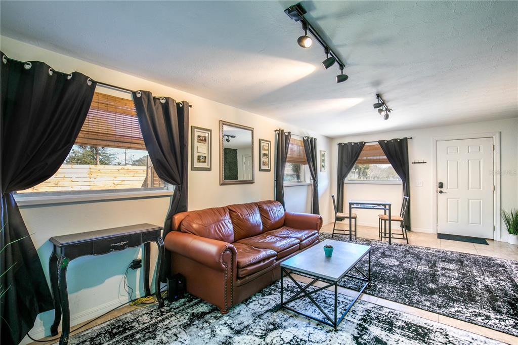 A living room features a brown leather sofa, a patterned rug, and track lighting — 901 HARMON AVENUE, WINTER PARK, FL