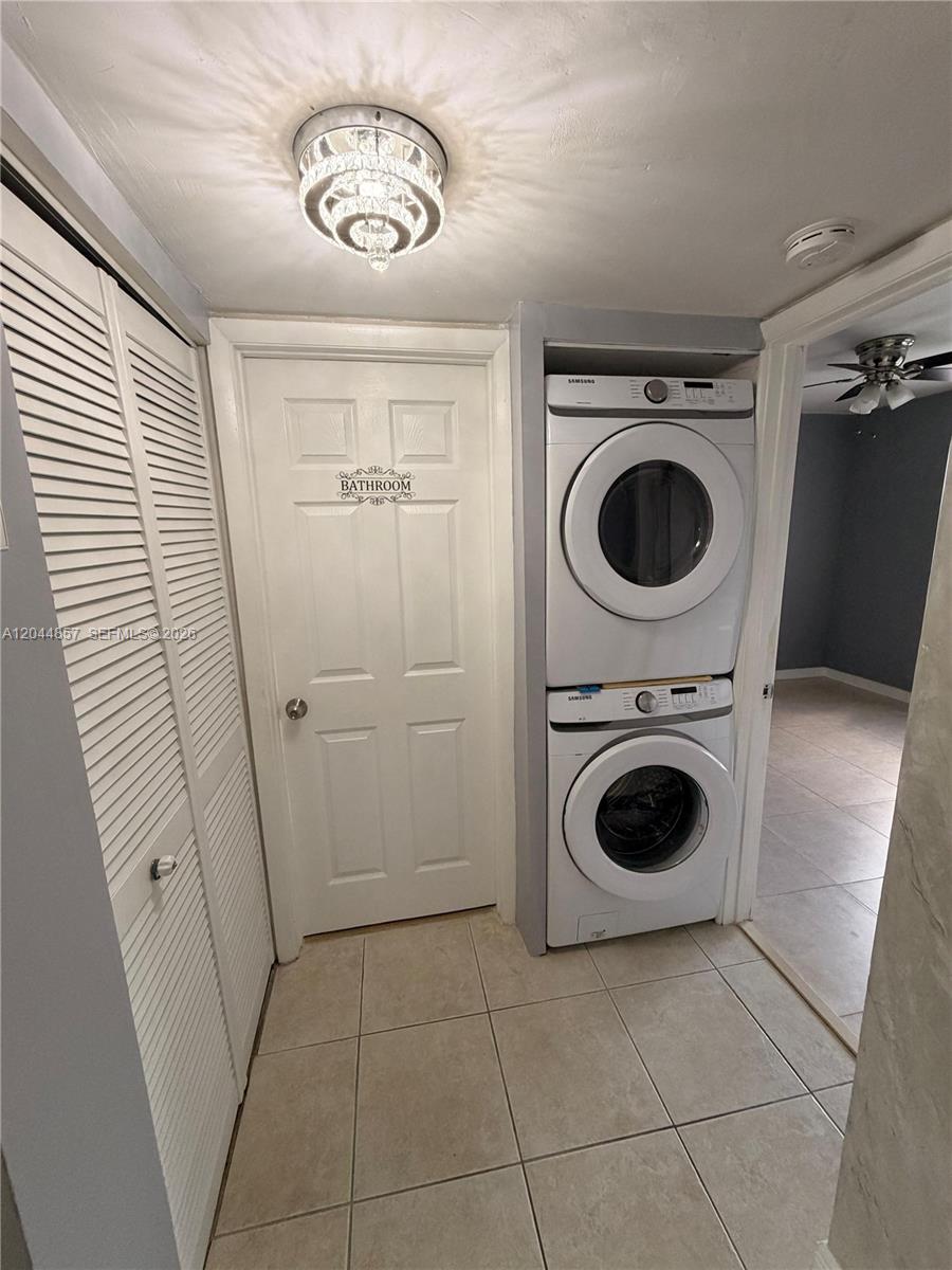 A laundry area features a stacked washer and dryer unit next to a bathroom door — 266 NW 60th Ave # 266, Margate FL 33063, MARGATE, FL