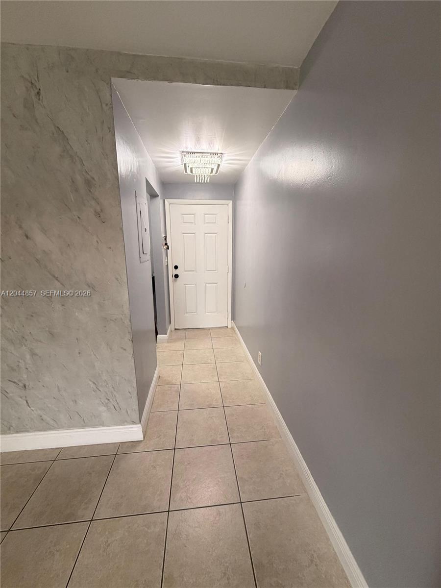 A tiled hallway leads to a white front door under a crystal chandelier — 266 NW 60th Ave # 266, Margate FL 33063, MARGATE, FL