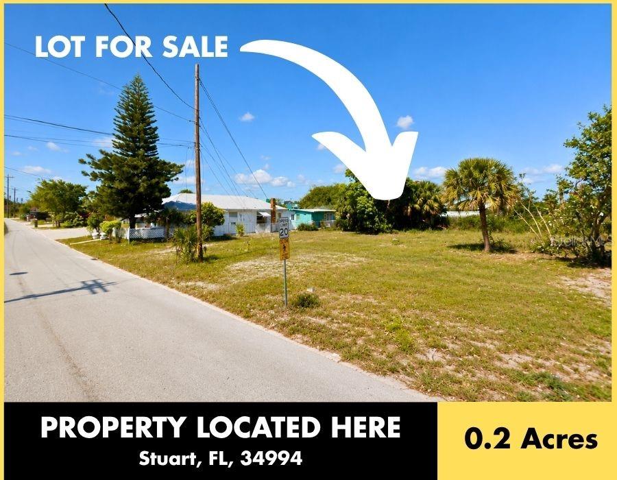 A vacant, grassy lot sits along a paved road next to a small residential house — 833 SE TARPON AVENUE, STUART, FL