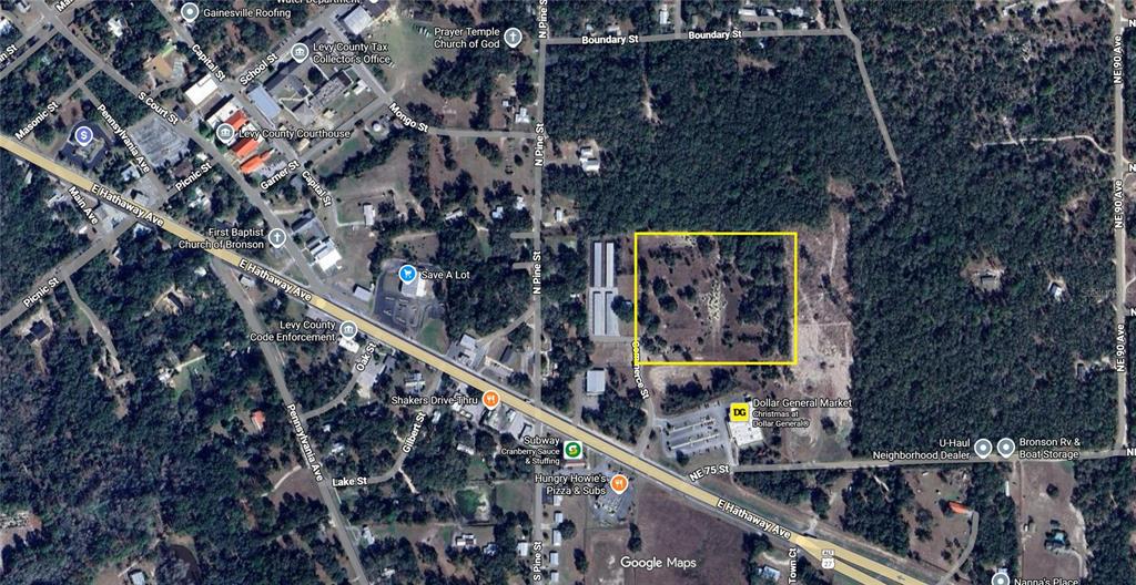 This is an aerial map showing a vacant, rectangular lot highlighted in yellow near businesses — TBD COMMERCE STREET, BRONSON, FL