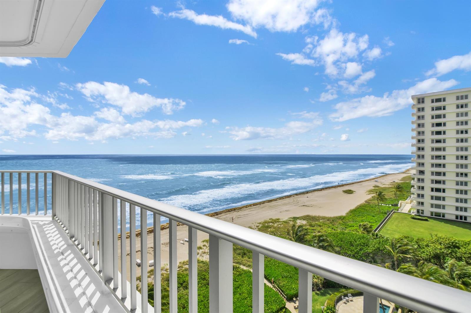 A balcony view overlooking the ocean, sandy beach, and a neighboring high-rise building — 550 S Ocean Boulevard # 1004, Boca Raton FL 33432, BOCA RATON, FL