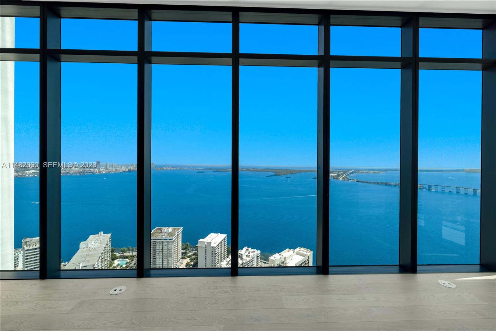 A room with floor-to-ceiling windows overlooking a bay, a bridge, and city buildings — 1451 Brickell Ave # 4403, Miami FL 33131, MIAMI, FL