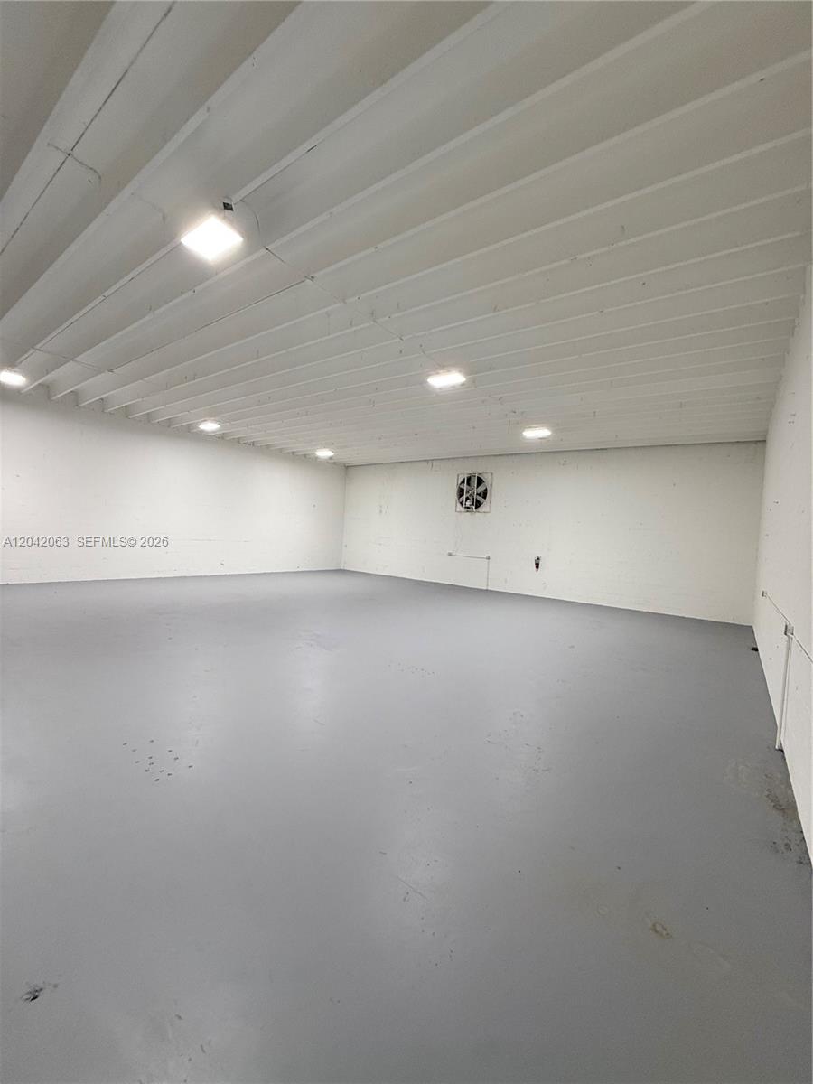 An empty warehouse space features a gray floor, white walls, and overhead lighting — MEDLEY, FL