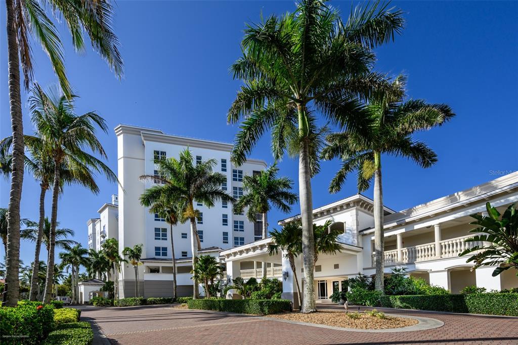 A screened balcony with a dining set overlooks a marina and a calm bay — 3313 SUNSET KEY CIRCLE UNIT 306, PUNTA GORDA, FL