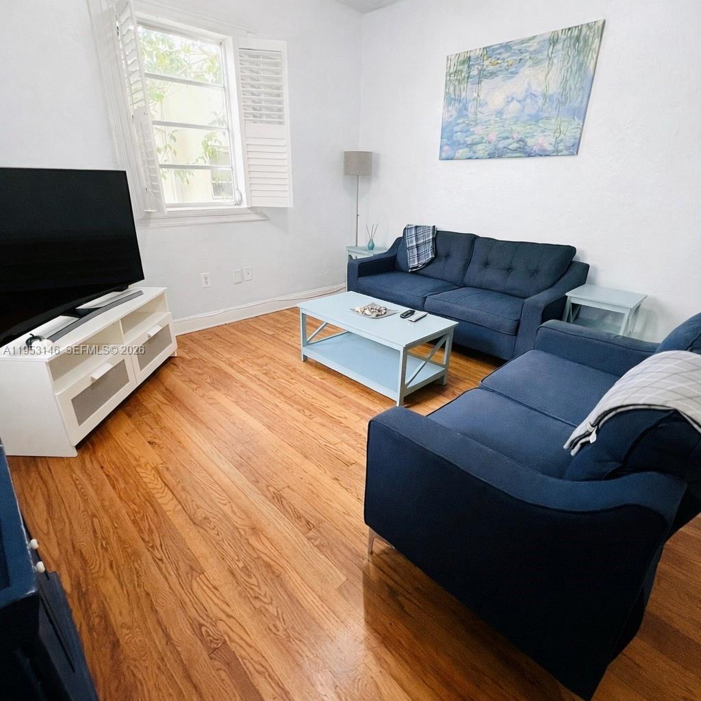 A living room features two blue sofas, a light blue coffee table, and hardwood floors — 928 Euclid Ave # 6, Miami Beach FL 33139, MIAMI BEACH, FL