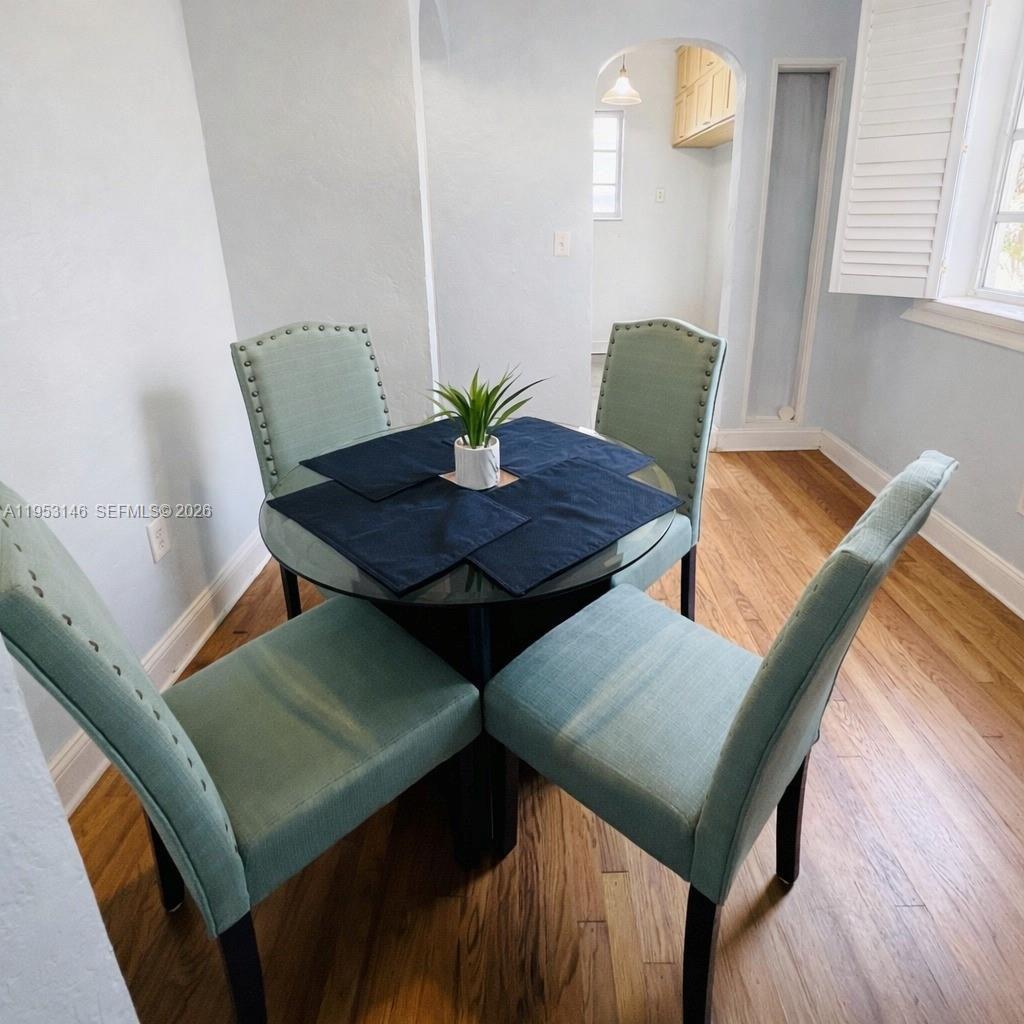 A dining area features a round glass table with four light green upholstered chairs — 928 Euclid Ave # 6, Miami Beach FL 33139, MIAMI BEACH, FL