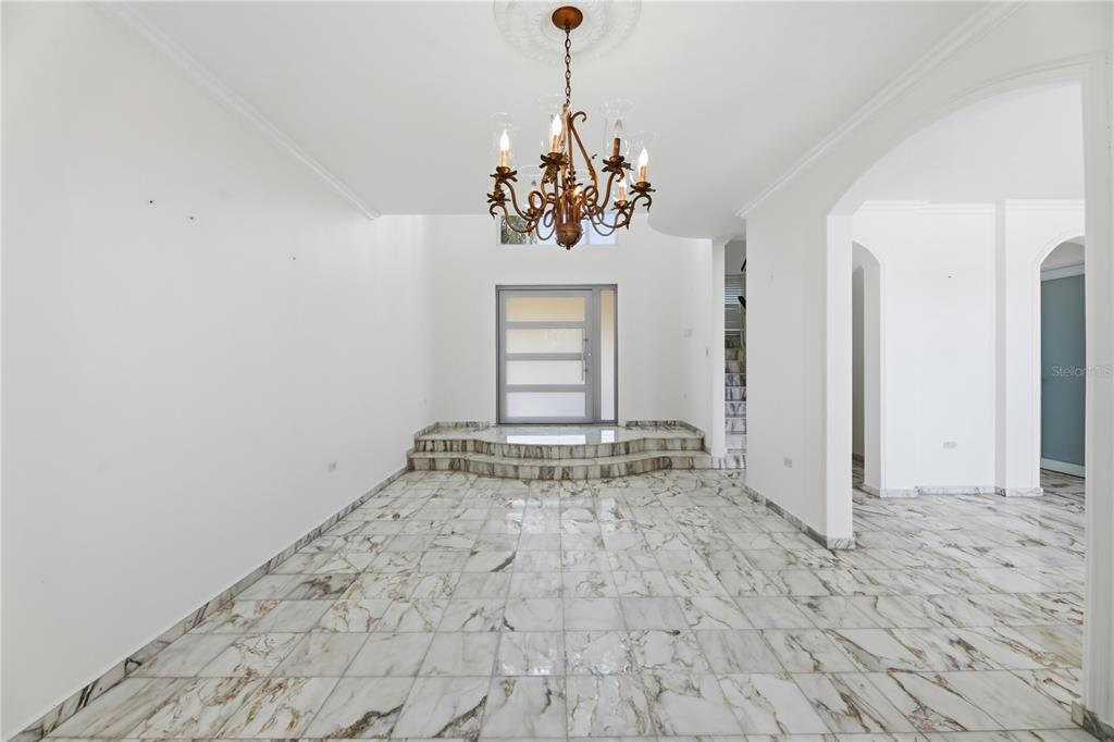A bright foyer features white marble tile flooring, a tiered entrance, and a hanging chandelier — 97 CALLE PITIRRE MONTEHIEDRAS, SAN JUAN, PR