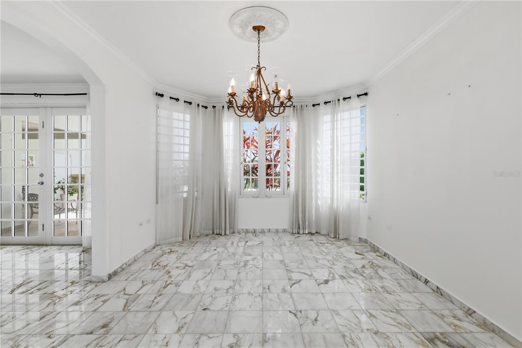 A dining room features marble tile flooring, a central chandelier, and large windows with curtains — 97 CALLE PITIRRE MONTEHIEDRAS, SAN JUAN, PR