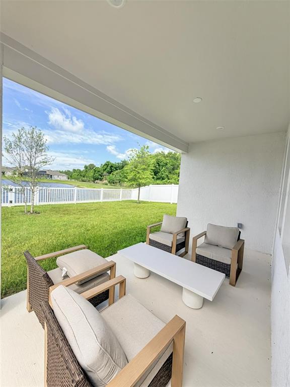 A covered patio features four wicker chairs and a white coffee table overlooking a yard — 639 TERRAPIN DRIVE, DEBARY, FL