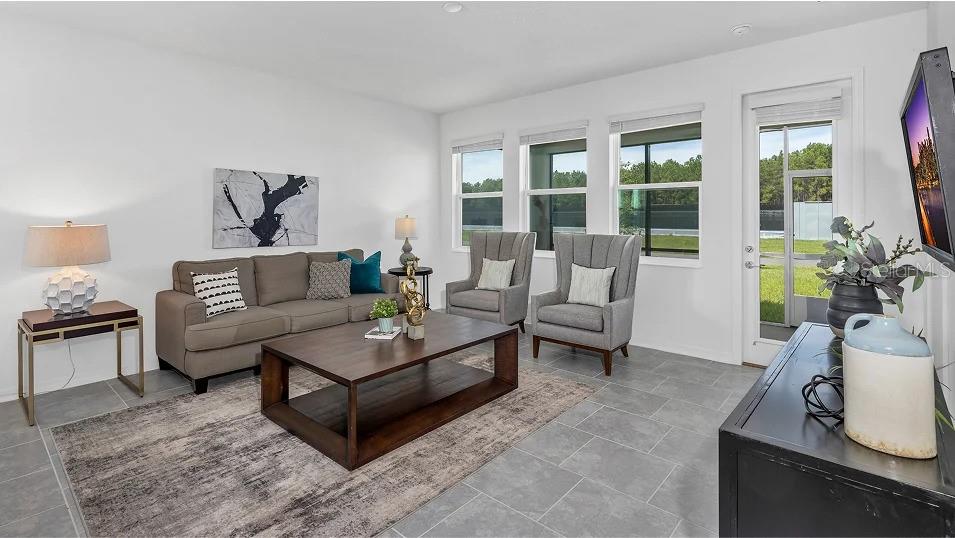 A living room features a gray sofa, two armchairs, a coffee table, and tile flooring — 639 TERRAPIN DRIVE, DEBARY, FL