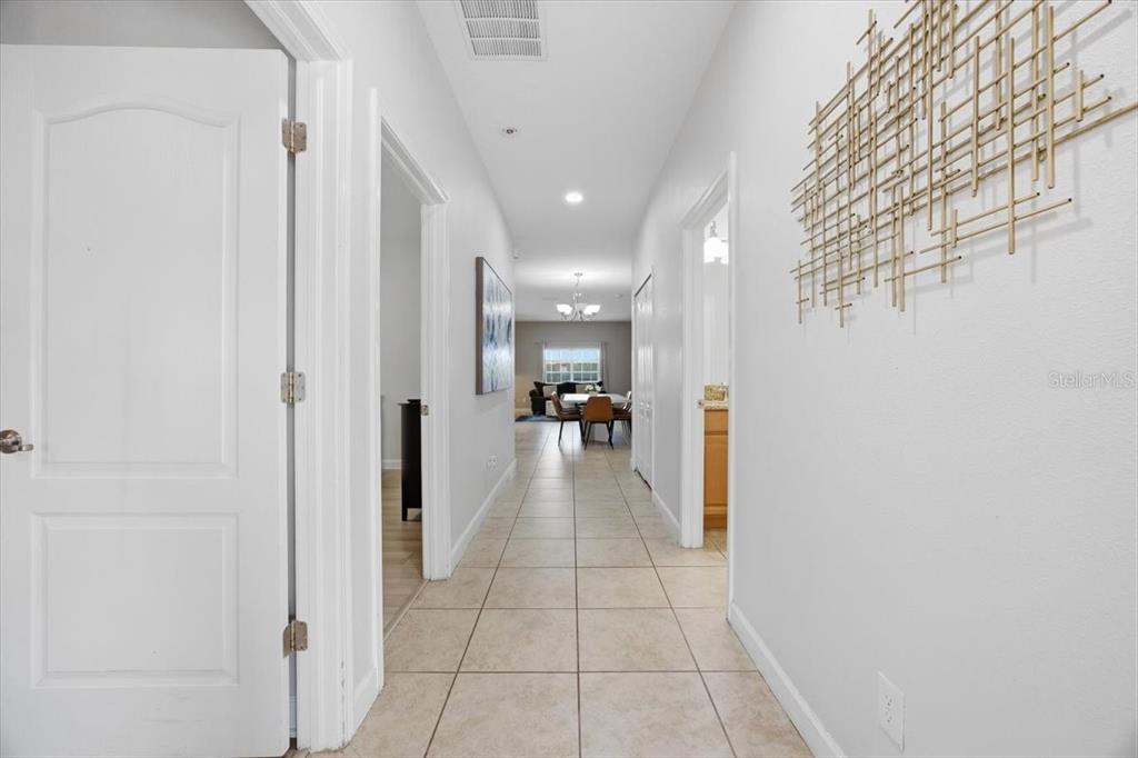 A tiled hallway leads from the foreground toward a dining area in the distance — 8922 CUBAN PALM ROAD, KISSIMMEE, FL